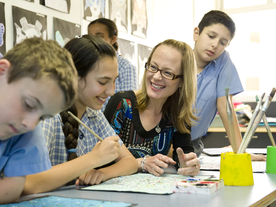Students painting with teacher